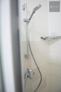 a shower with a shower head in a bathroom at HHC Apartments Kronos in Paramaribo +20 photos