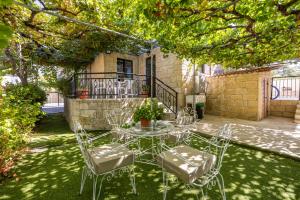 TrimikliniJP Pool House的一个带桌子和椅子的院子,有一座建筑