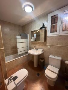 Un baño con un inodoro blanco y un lavabo. en BUENAVISTA zona media, en Sierra Nevada 6 fotos más