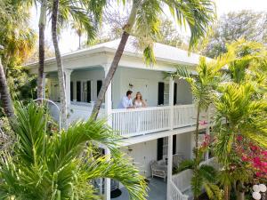 a couple standing on the balcony of a house at The Gardens Hotel in Key West