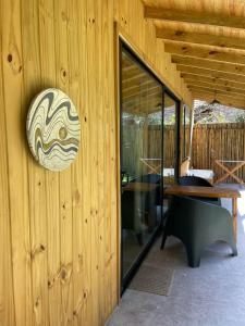 a room with a wooden wall with a glass door at Increíble cabaña, naturaleza, a 300m del mar, Pinamar in Pinamar
