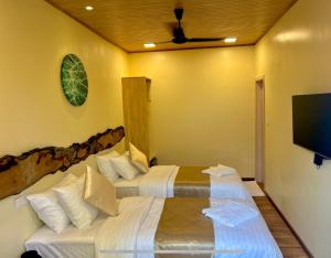 a bedroom with two beds and a flat screen tv at Holiday Home Dhiffushi in Dhiffushi