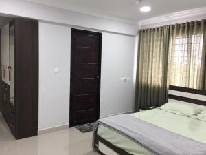 a bedroom with a bed and a wooden door at Luxurious 2 bedroom apartment in Thiruvalla town in Thiruvalla