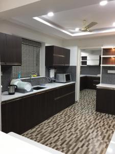 a kitchen with dark brown cabinets and a kitchenasteryasteryasteryasteryasteryasteryastery at Luxurious 2 bedroom apartment in Thiruvalla town in Thiruvalla +7 photos