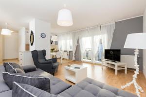 a living room with a couch and a tv at Jantar Apartamenty - Wylotowa in Kołobrzeg