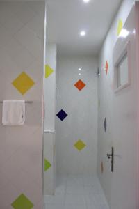 y baño con ducha y azulejos de colores. en Auberge Tinit en Er-Rachidía