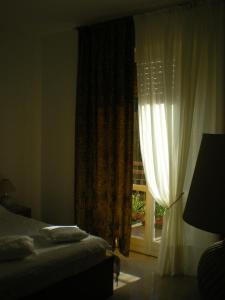 een slaapkamer met een bed en een raam met gordijnen bij Casa Dorotina in Mozzo