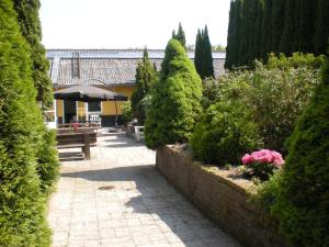 a garden with trees and bushes and a patio at Danninghus in Vindeby