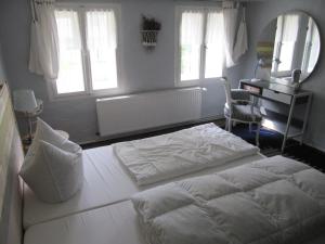 1 Schlafzimmer mit 2 Betten, einem Schreibtisch und Fenstern in der Unterkunft Villa Romantica Lenzen in Körbitz + 15 Fotos