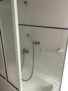 une douche avec un tuyau dans une salle de bain dans l'établissement Corações Unidos "A Pensão", à Alcobaça 22 autres photos