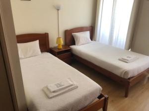 deux lits jumeaux dans une chambre avec fenêtre dans l'établissement Corações Unidos "A Pensão", à Alcobaça