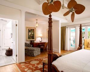 a bedroom with a bed with a ceiling fan at The Gardens Hotel in Key West +37 photos