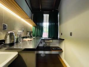 a kitchen with a black counter top and a window at Loft 205 em frente à Vila Germânica- Villa Haus in Blumenau