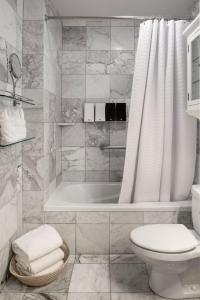 a bathroom with a tub and a toilet and a sink at The Gardens Hotel in Key West