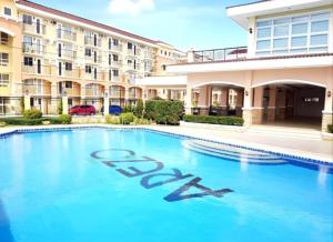 a swimming pool in front of a building at REI365 Condotel in Davao City