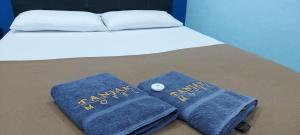a bed with two blue towels on it at Tanjak Hotel in Alor Setar +27 photos