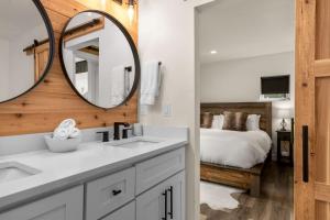 a bathroom with a sink and a mirror and a bed at Modern Mountain Townhouse at The Quarry in Whitefish +41 photos