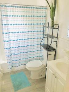a bathroom with a toilet and a shower curtain at Zen in Fort Lauderdale