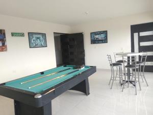 a pool table in a room with bar stools at Casa grande in Cañada del Rodeo