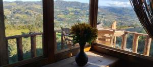 a vase with flowers sitting on a window sill at Casiopea Glamping in Tabio