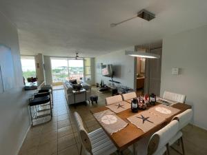 a dining room and living room with a table and chairs at Ocean & Marina Views 3 Bedroom 2 Bathroom Luxury Condo in Fajardo