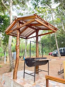 a barbecue grill with a wooden roof on top of it at Cabaña Tu Lugar Favorito in Santa Elena