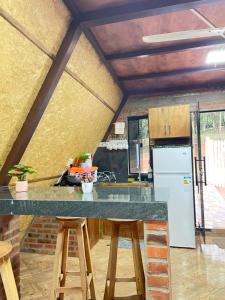 a kitchen with a counter and stools in a room at Cabaña Tu Lugar Favorito in Santa Elena