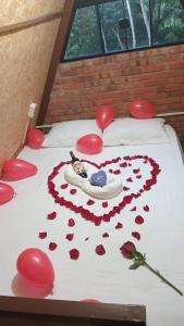 a bed with a heart made out of red roses at Cabaña Tu Lugar Favorito in Santa Elena