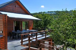 eine Holzhütte mit einer Terrasse mit einem Tisch und Stühlen in der Unterkunft Mars in La-Roche-en-Ardenne