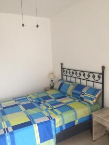 a bedroom with a bed with a blue and yellow comforter at Casa Bella Salinas in Salinas