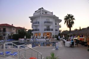 a large white building with a pool in front of it at Nevada Hotel & Spa in Fethiye