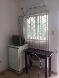 a desk with a tv and a chair next to a window at Casa Bella Salinas in Salinas