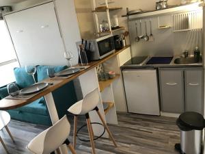 a kitchen with a table and chairs in a room at Studio Hypercentre - FRONT DE MER - Grande Plage - piscine in Biarritz
