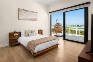a bedroom with a bed and a large window at Maresia Villa - Luxurious Villa with Infinity Pool, Rooftop and Amazing Views in Providenciales +6 photos