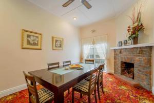 a dining room with a table and chairs and a fireplace at Cambridge House, Bendigo in Bendigo +14 photos