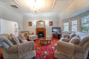a living room with two couches and a fireplace at Cambridge House, Bendigo in Bendigo