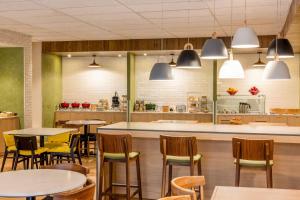 a restaurant with tables and chairs and a kitchen at Fairfield by Marriott Inn & Suites Cancun Downtown in Cancún