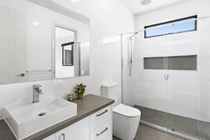 a white bathroom with a sink and a shower at Seaside Retreat, St Leonards in Saint Leonards +8 photos