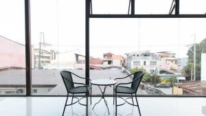 twee stoelen en een tafel voor een raam bij RedDoorz at San Antonio Makati in Manilla