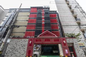 Un edificio alto con una puerta roja al costado. en Hotel KoJaJa, en Incheon