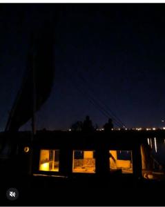 two people standing on a boat at night at Aswan in Aswan +1 photo