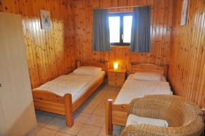2 Einzelbetten in einem Zimmer mit Holzwänden in der Unterkunft Aimant in Somme-Leuze
