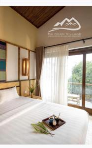 a bedroom with a bed with a tray on it at Bakhan Village Resort in Mai Châu
