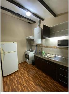 a kitchen with a white refrigerator and a sink at La casita in Villa Carlos Paz