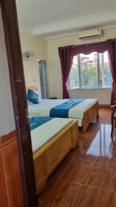 a bedroom with two beds and a window at KHÁCH SẠN HÀ ANH 1 NỘI BÀI in Noi Bai