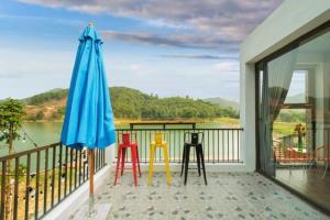 a balcony with a table and chairs and an umbrella at LaLa Villas in Hòa Bình