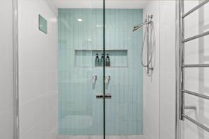 a shower with a glass door in a bathroom at Pacific Breeze in Caves Beach +28 photos