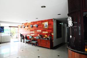 a living room with a red and white wall at Choktawee Smile in Chiang Mai