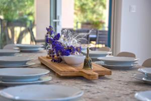 a table with white plates and a bowl of blue flowers at Villa J&J in Kastel Novi