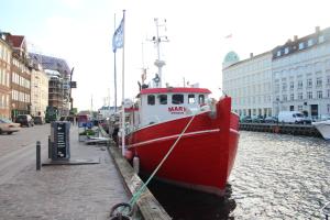 a red and white boat is docked in the water at MS Mary -Nyhavn in Copenhagen